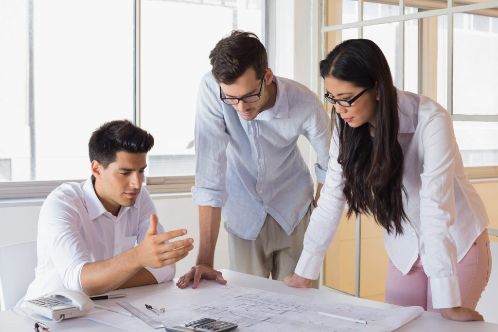 Diseñadores examinando los planos de la vivienda